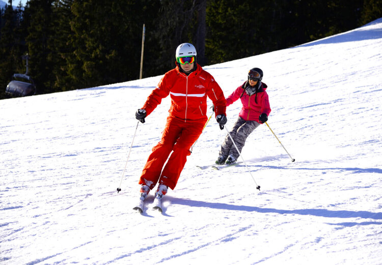 Skileher mit Skischüler auf der Piste