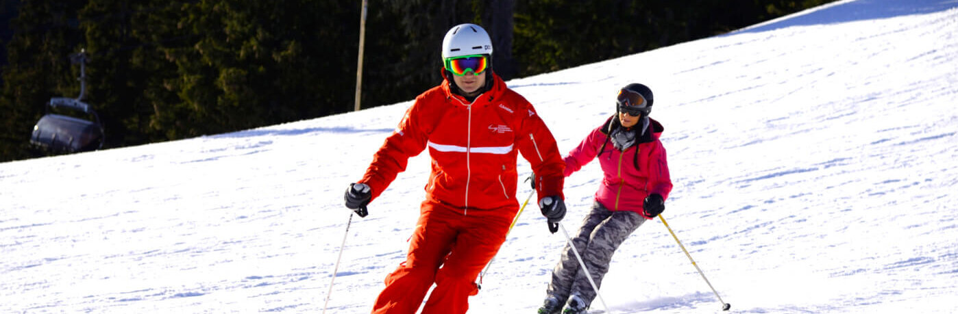 Skileher mit Skischüler auf der Piste